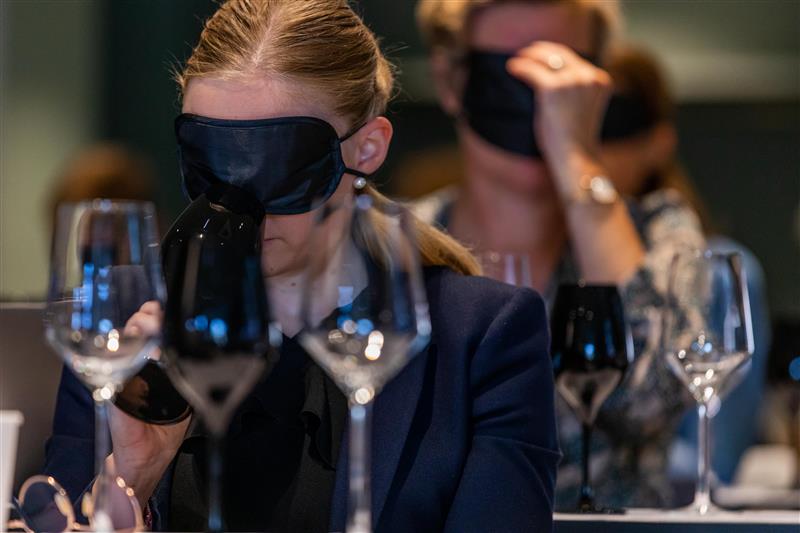 Two wine glasses—one filled with white wine and one with red—set against a soft, ambient background.